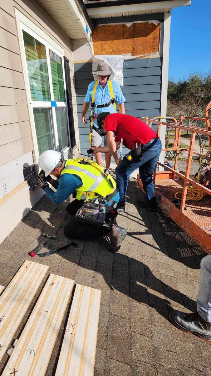 A group of construction workers are working on a house.