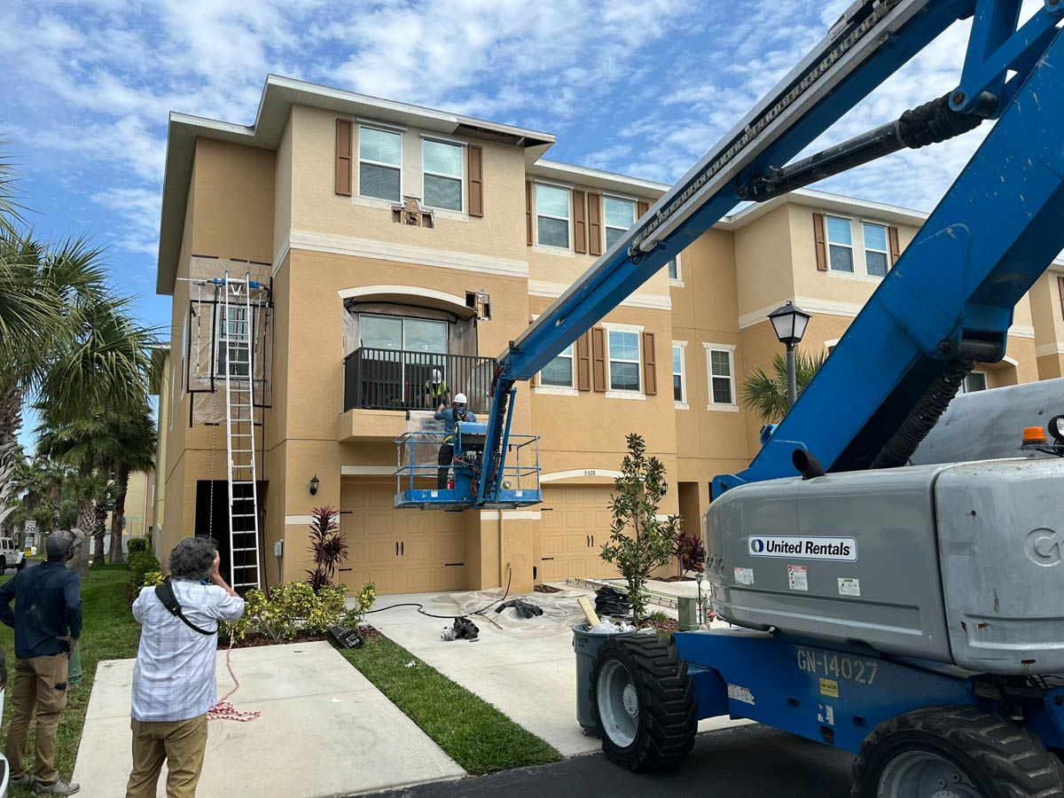 A man is taking a picture of a building with a crane.