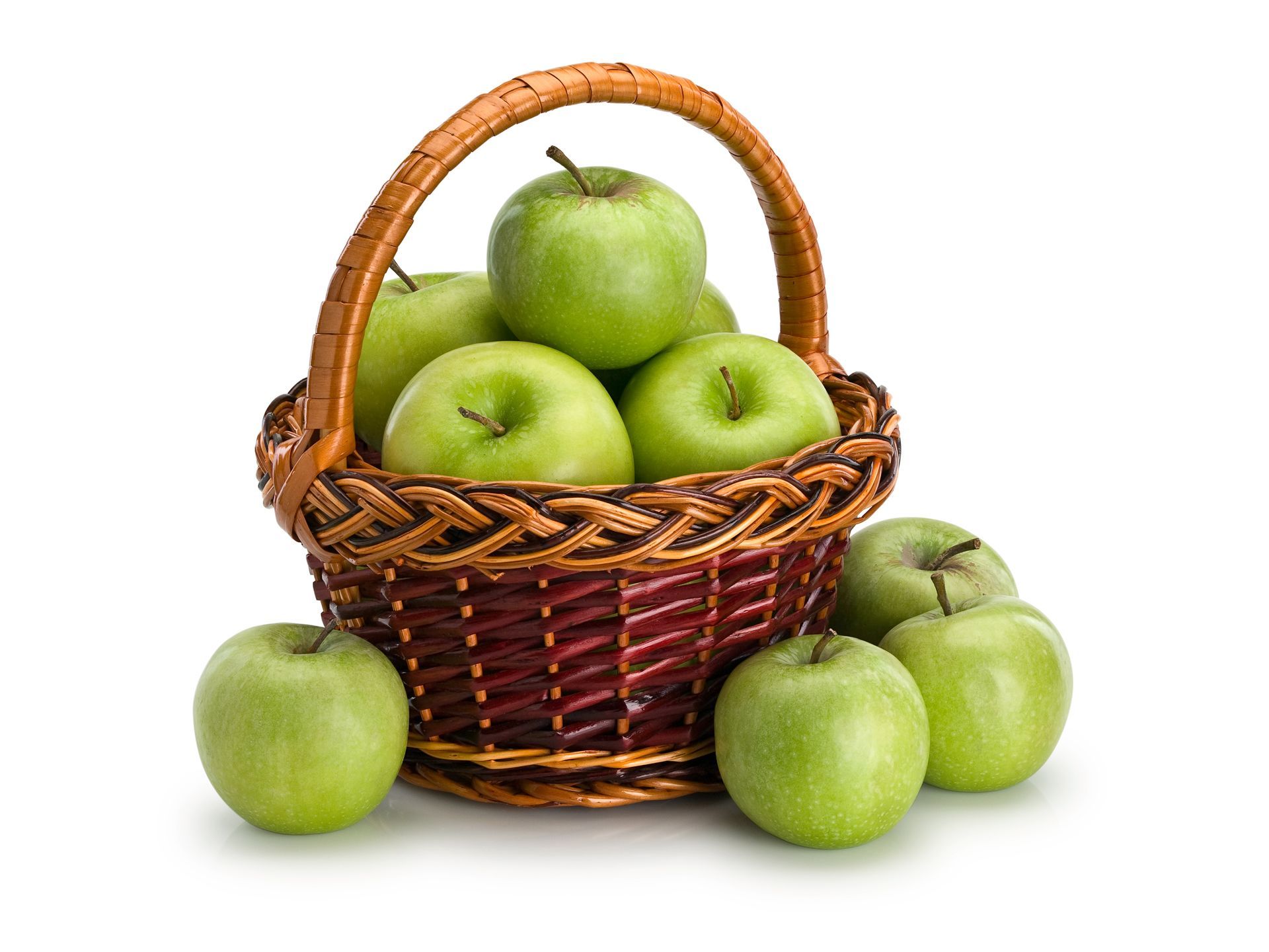 A basket overflowing with green apples on a white background.