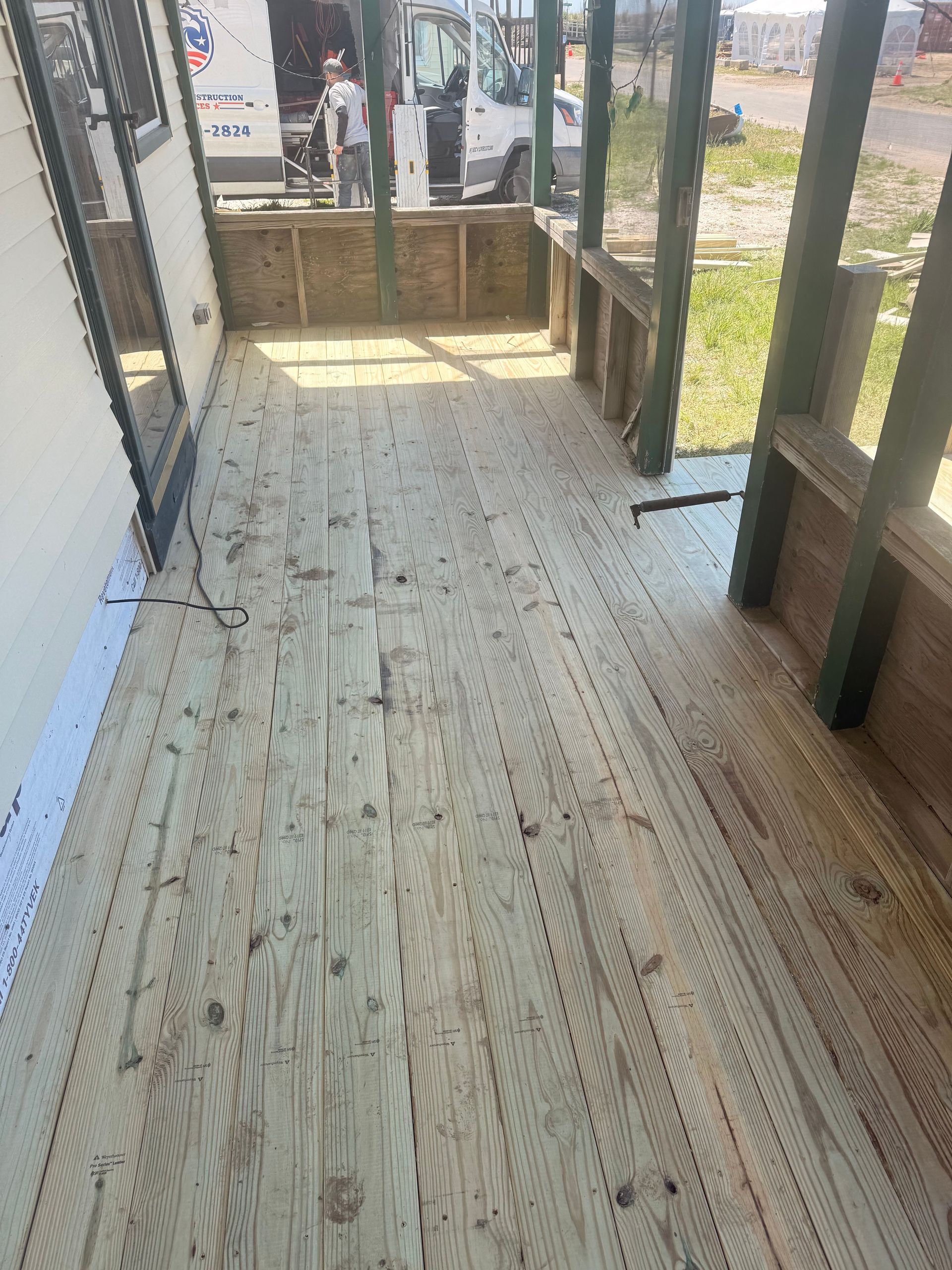 Wooden porch ramp leading to a doorway, with railings and a small outdoor landing.