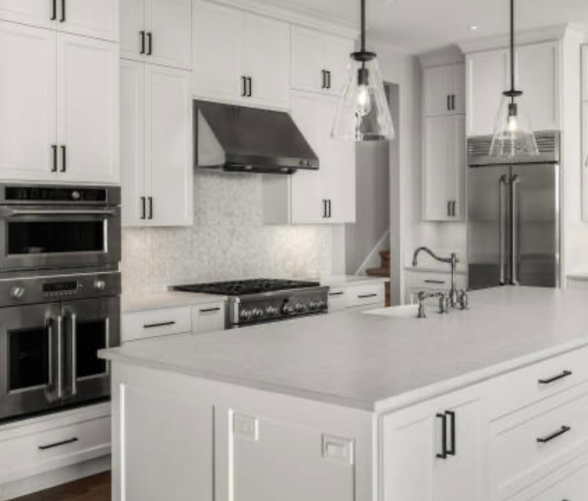 Bright modern white kitchen with stainless steel appliances, island, and pendant lights