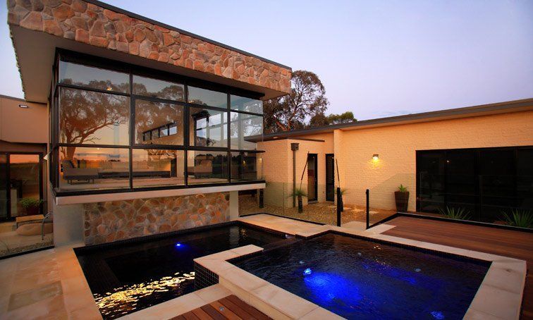 A Large House With A Large Swimming Pool In Front Of It — Mediterranean Custom Pools In Kialla, VIC