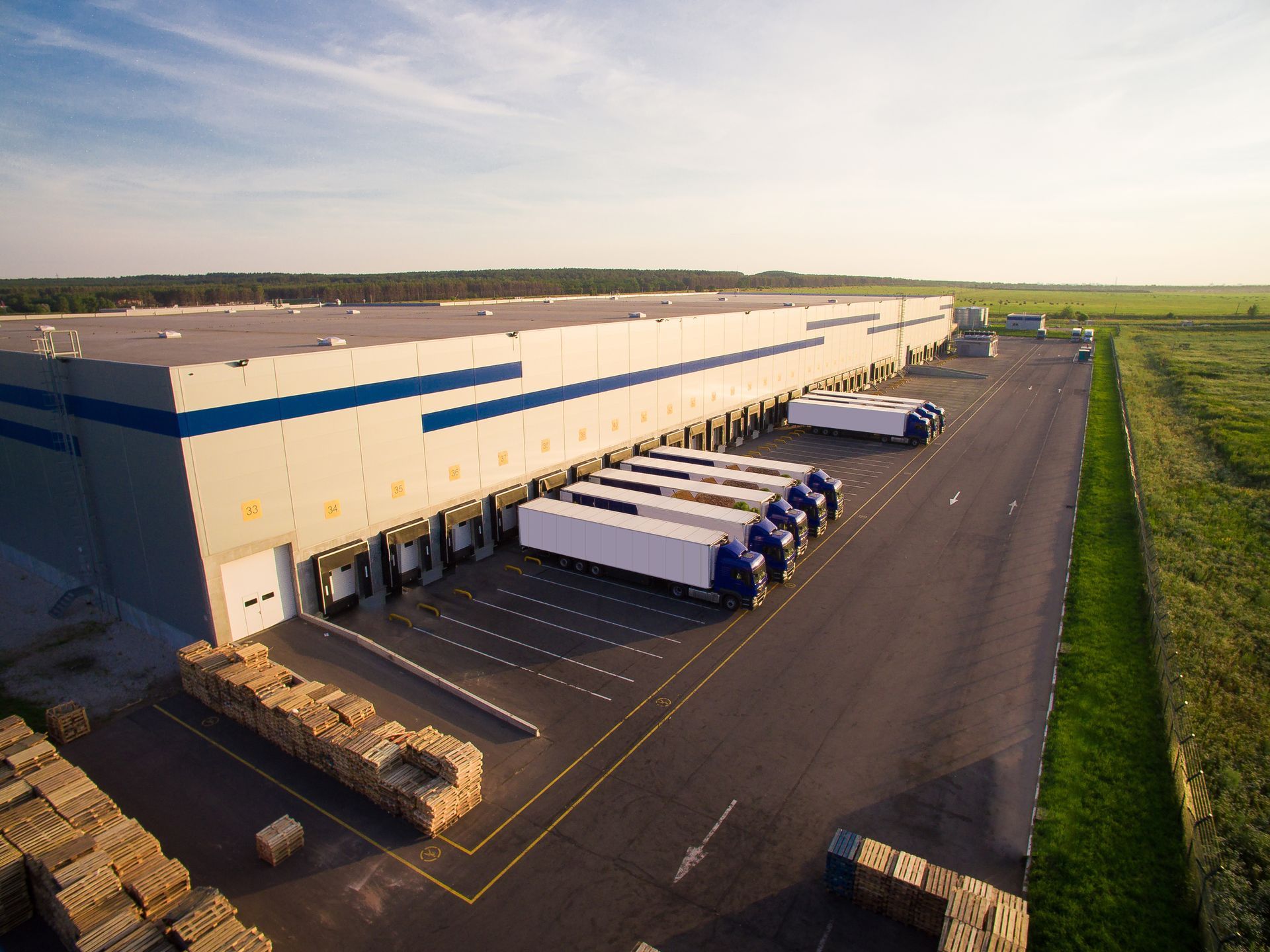 The exterior of a warehouse with trucks representing warehousing and distribution services