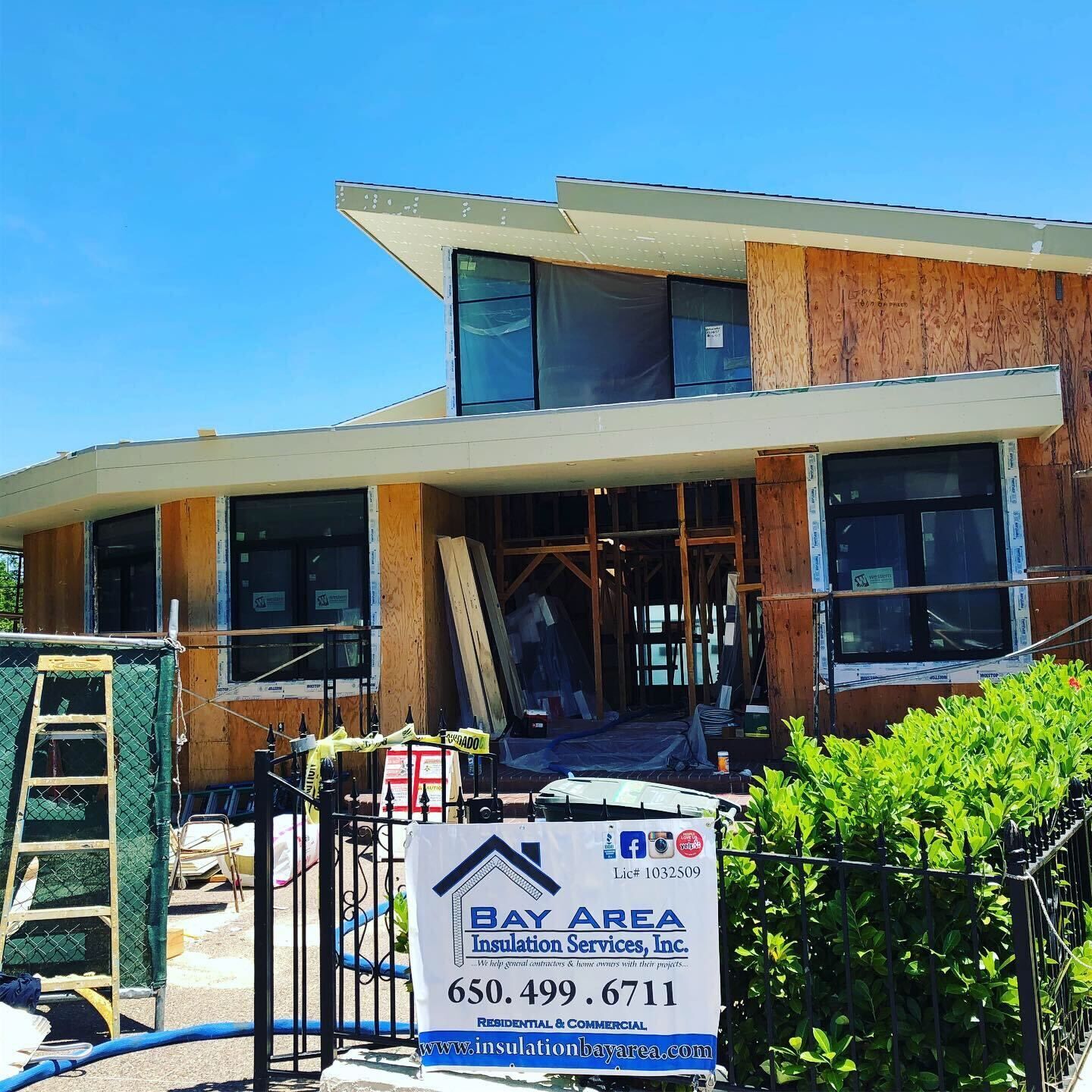 Damaged house under repair with a Bay Area Building Services sign in front
