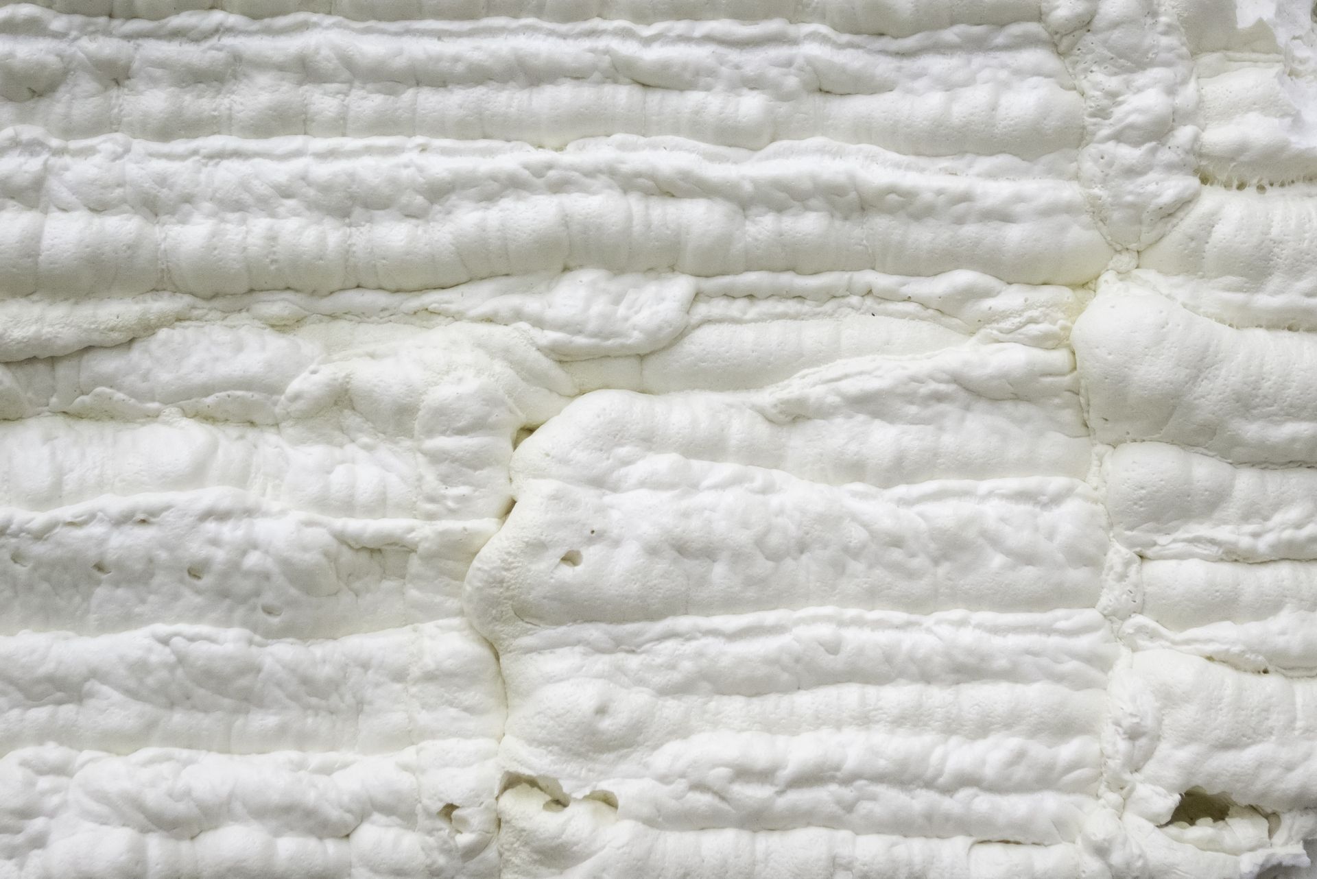 Close-up of wrinkled white fabric with horizontal folds and soft texture