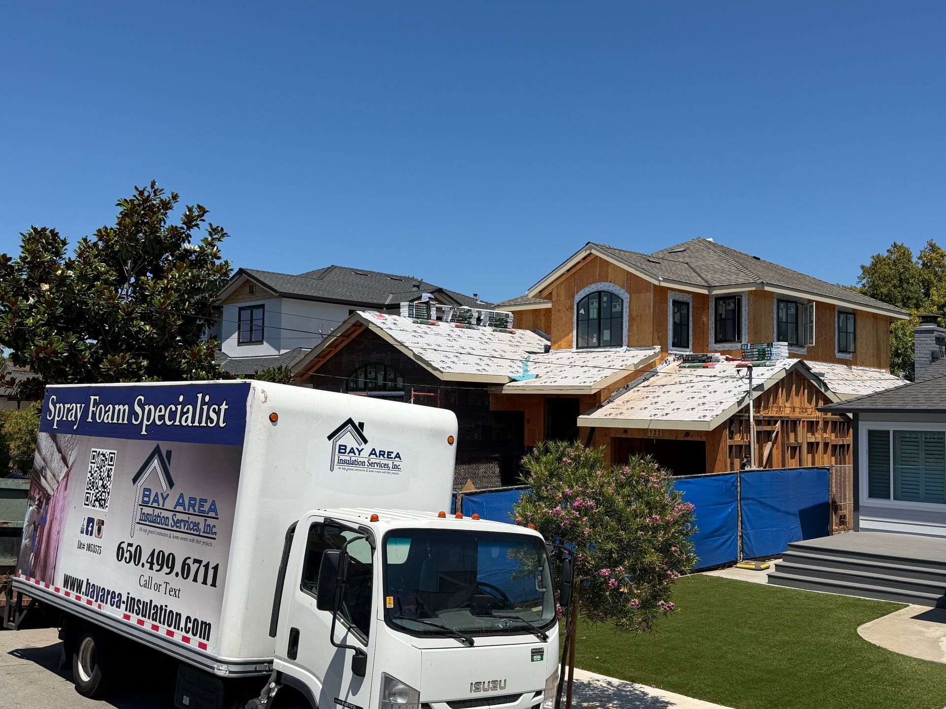 Moving truck parked in front of a house under construction on a sunny day