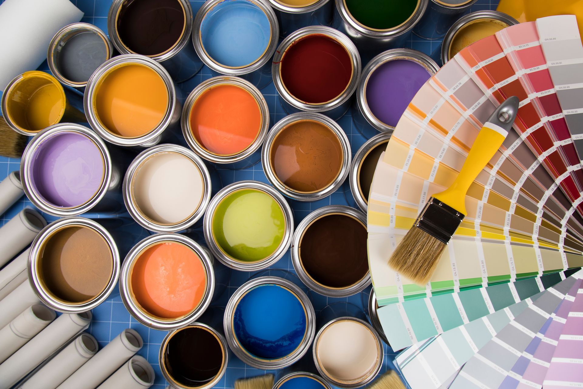 Open paint cans with a color fan swatch showing assorted hues.