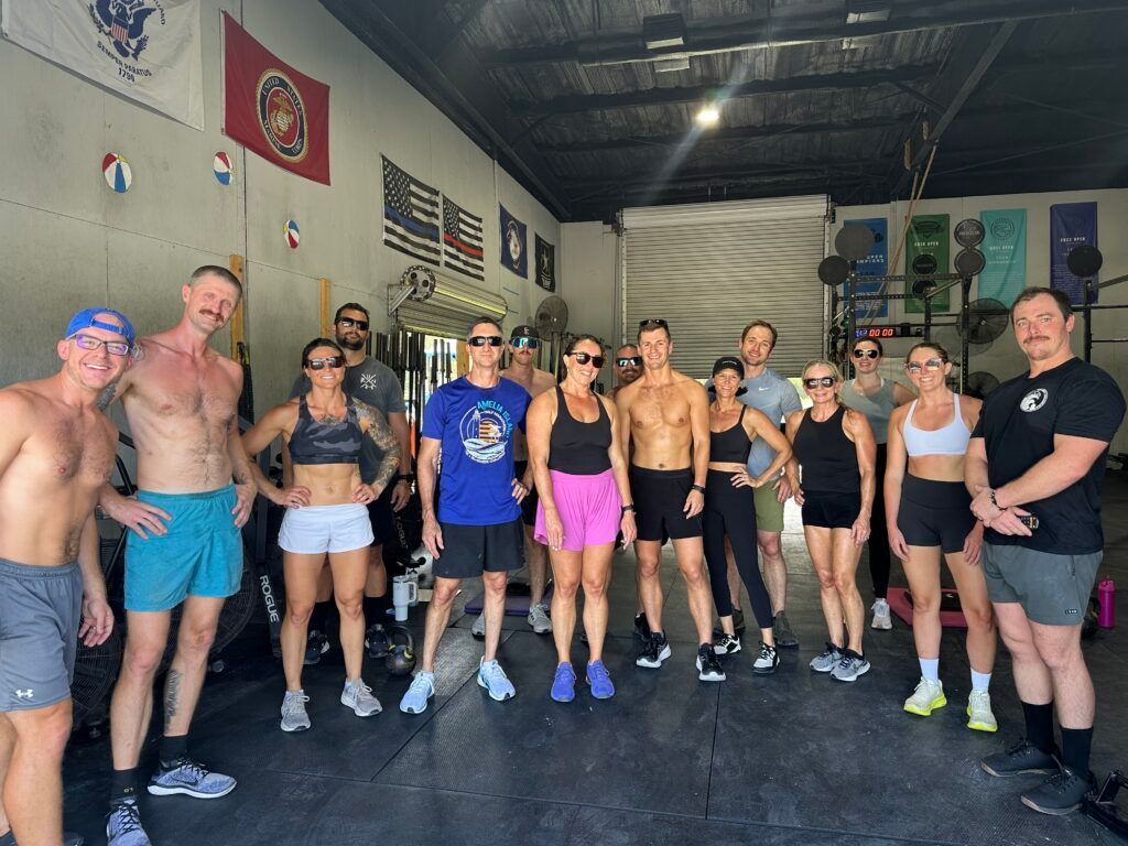 Group of athletes posing together in CrossFit Fernandina in Yulee,FL, wearing workout clothes and smiling