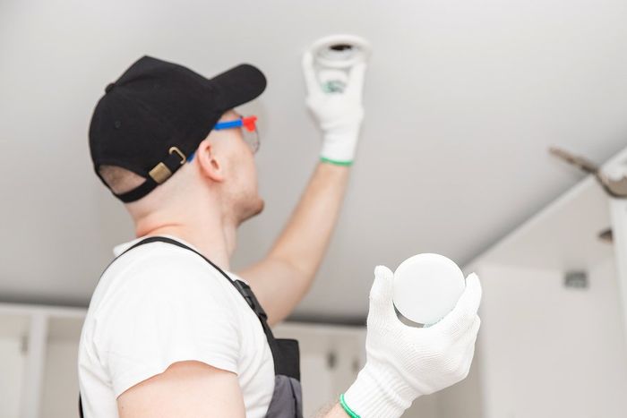 worker installing the lightbulb