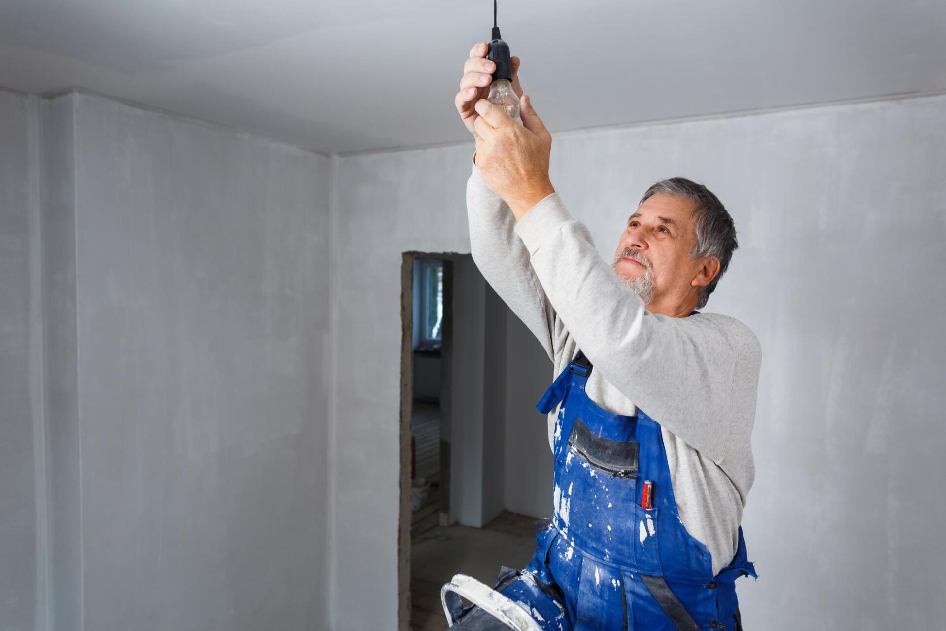 electrician installing the lightbulb