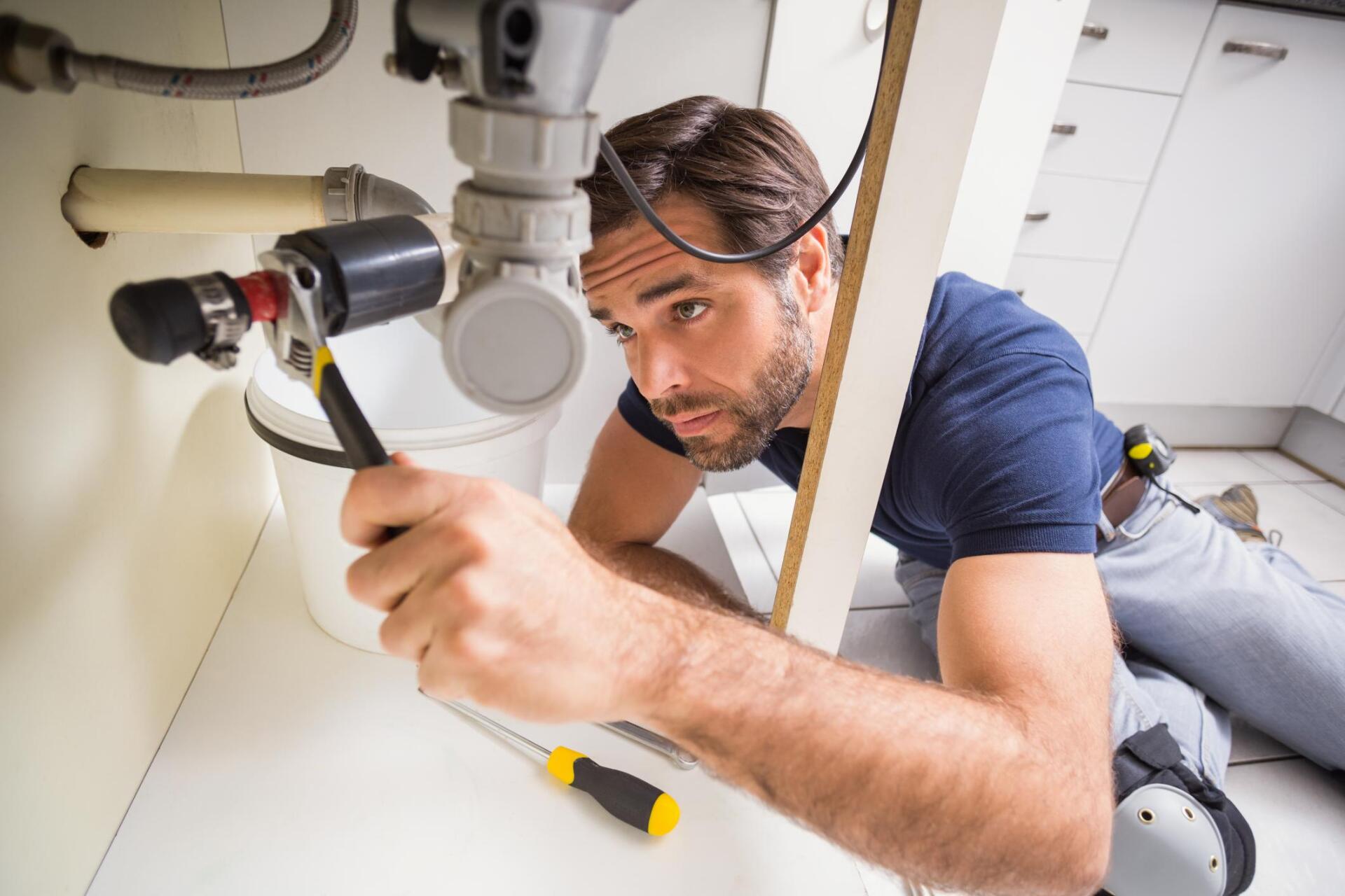 plumber fixing the water pipe