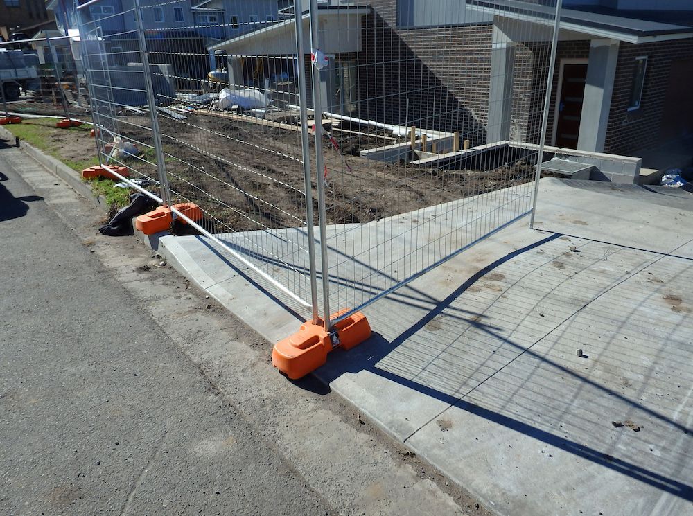 Construction Site Fence With Orange Bases on Concrete — Fud's Concreting In Bowen, QLD