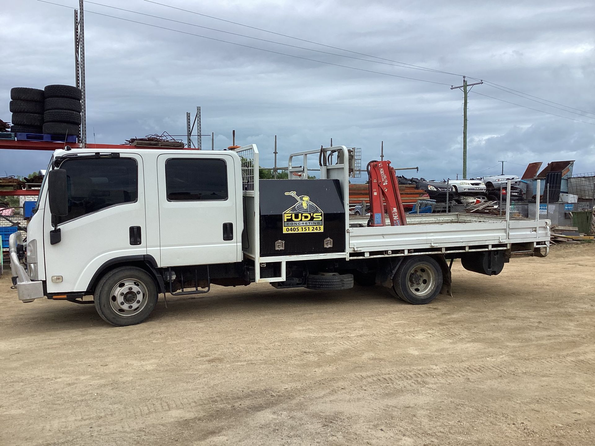 Construction Site With Concrete Pillars, Yellow Crane, and Orange Truck — Fud's Concreting In Bowen, QLD