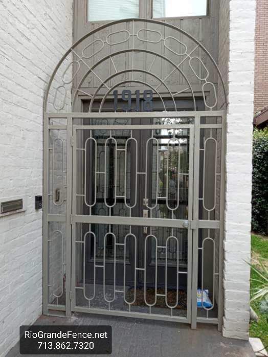 A Wrought Iron Gate Is in Front of A White Brick Building - Houston, TX - Rio Grande Fence Company