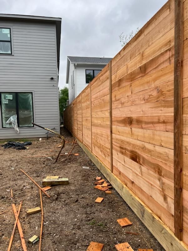 A Wooden Fence Is Being Built in The Backyard of A House - Houston, TX - Rio Grande Fence Company