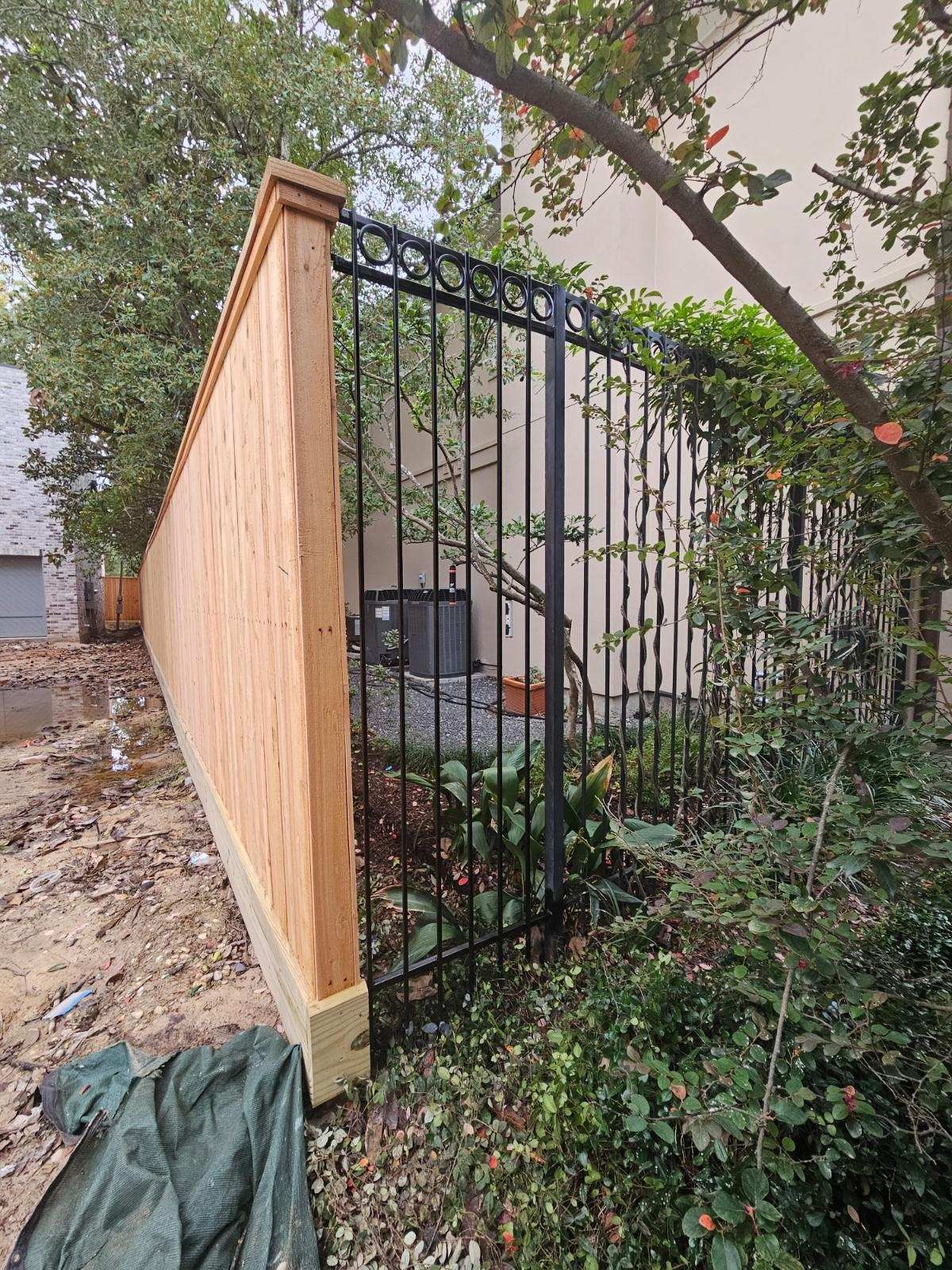 A Wooden Fence With A Metal Gate in Front of A House - Houston, TX - Rio Grande Fence Company