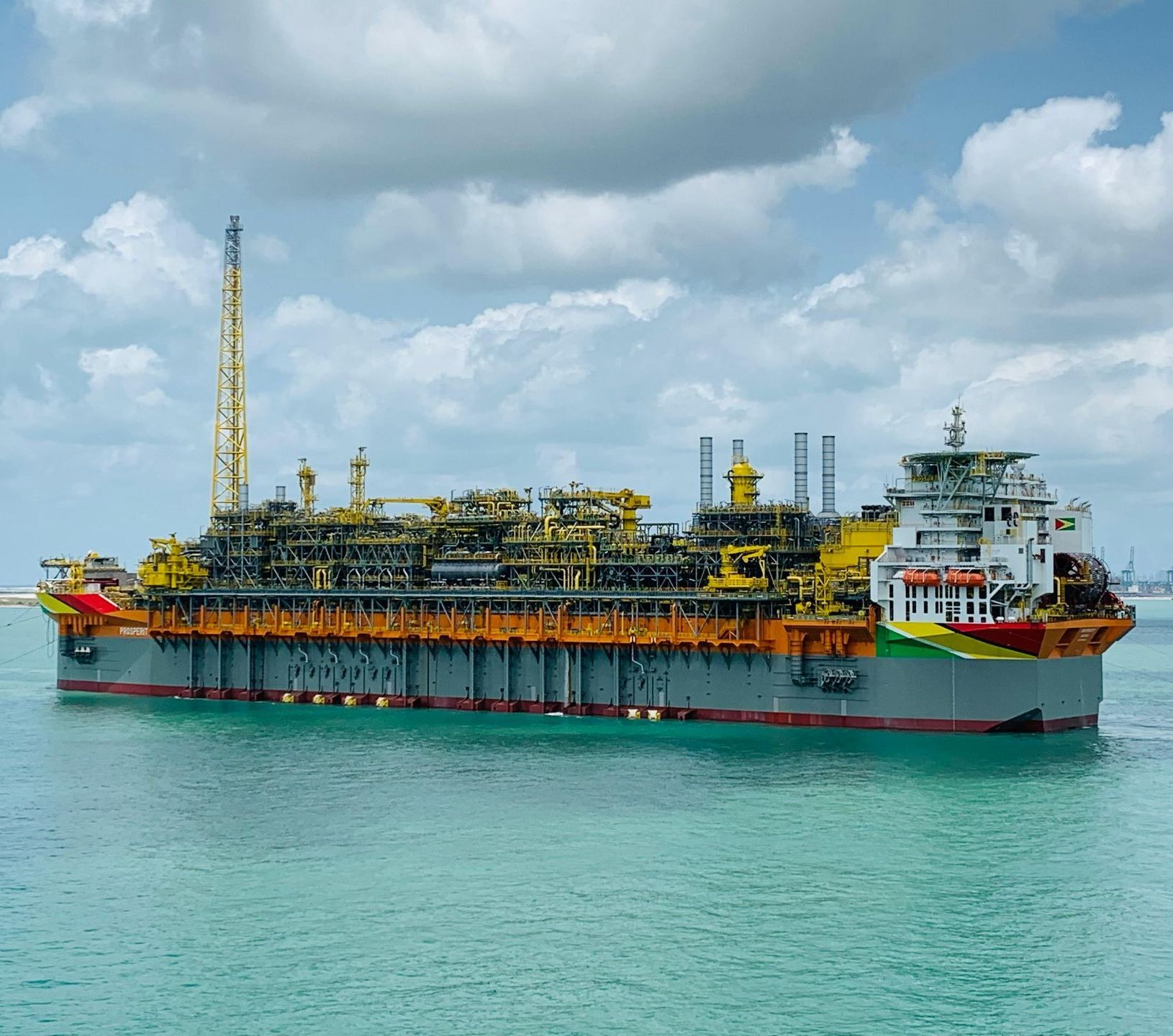 A large cargo ship is floating on top of a body of water.