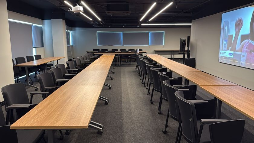 Dois homens conversando à mesa em uma sala com decoração em estilo industrial.