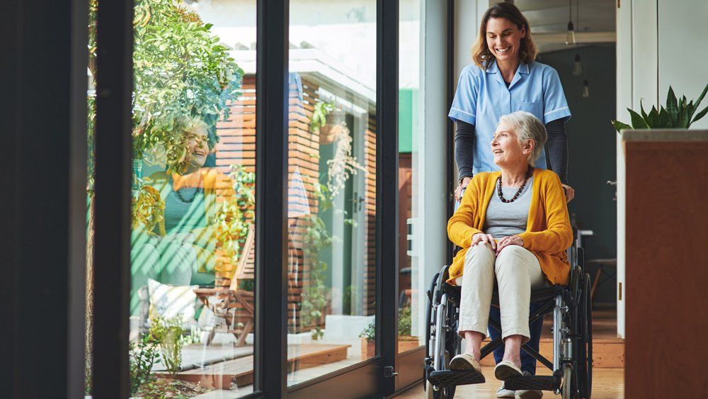 Nurse Assisting Patient On Wheelchair — Great Falls, MT — Senior Insurance Market Nurse Assisting Patient On Wheelchair — Great Falls, MT — Senior Insurance Market