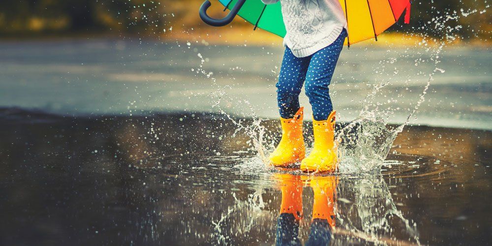 Child Jumping In Puddle In Gumboots — Quality Shoe Shop in Maroochydore, QLD