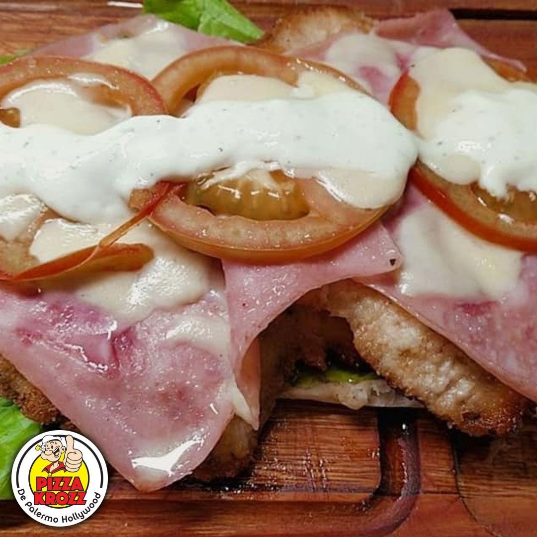Chuleta de pollo empanizada cubierta con jamón, queso derretido