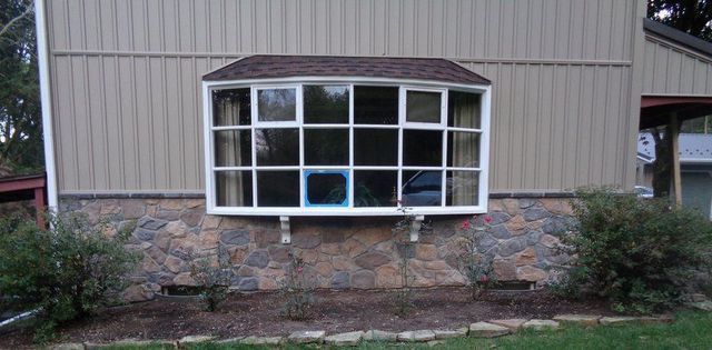 A House with A Large Window on The Side of It.