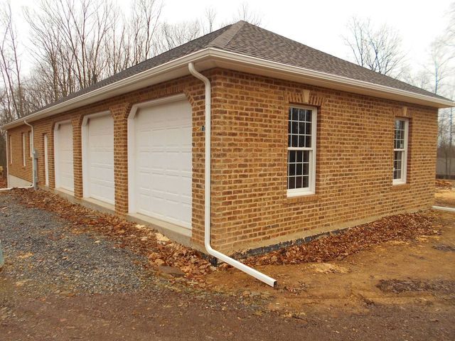 A Brick Garage with White Garage Doors and Windows