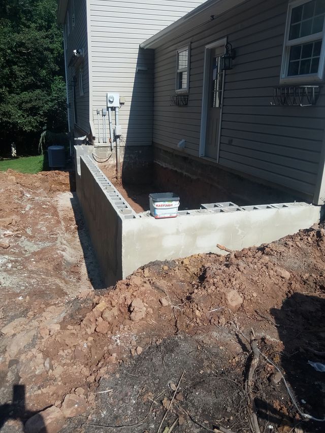 A Concrete Wall Is Being Built in Front of A House
