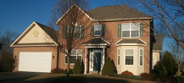 A Large Brick House with A White Garage Door