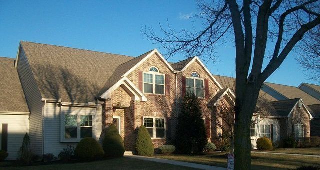 A Large Brick House with A Tree in Front of It
