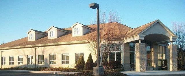 A Large White Building with A Brown Roof and A Lot of Windows