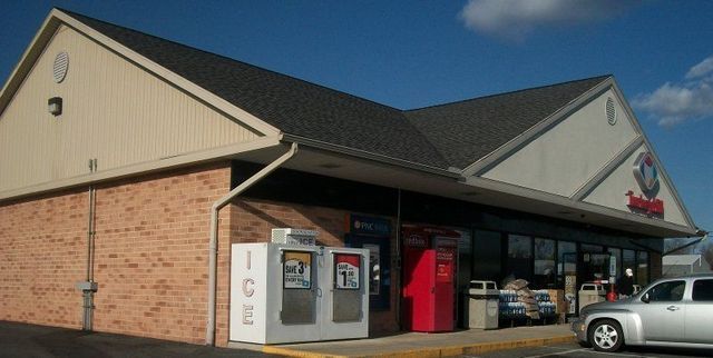 A Silver Car Is Parked in Front of A Gas Station
