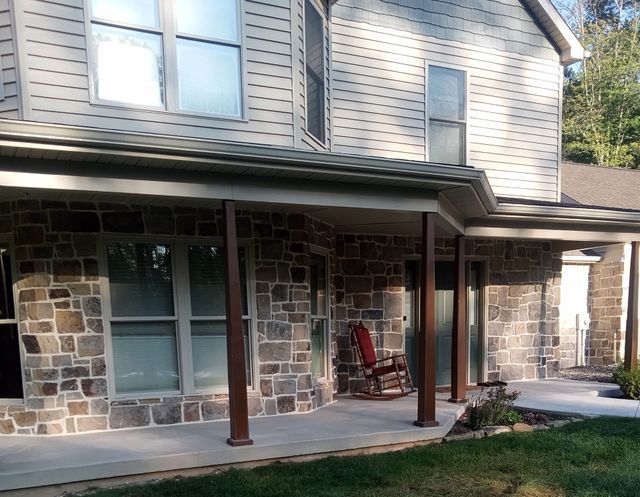 There Is a Rocking Chair on The Porch of A House.