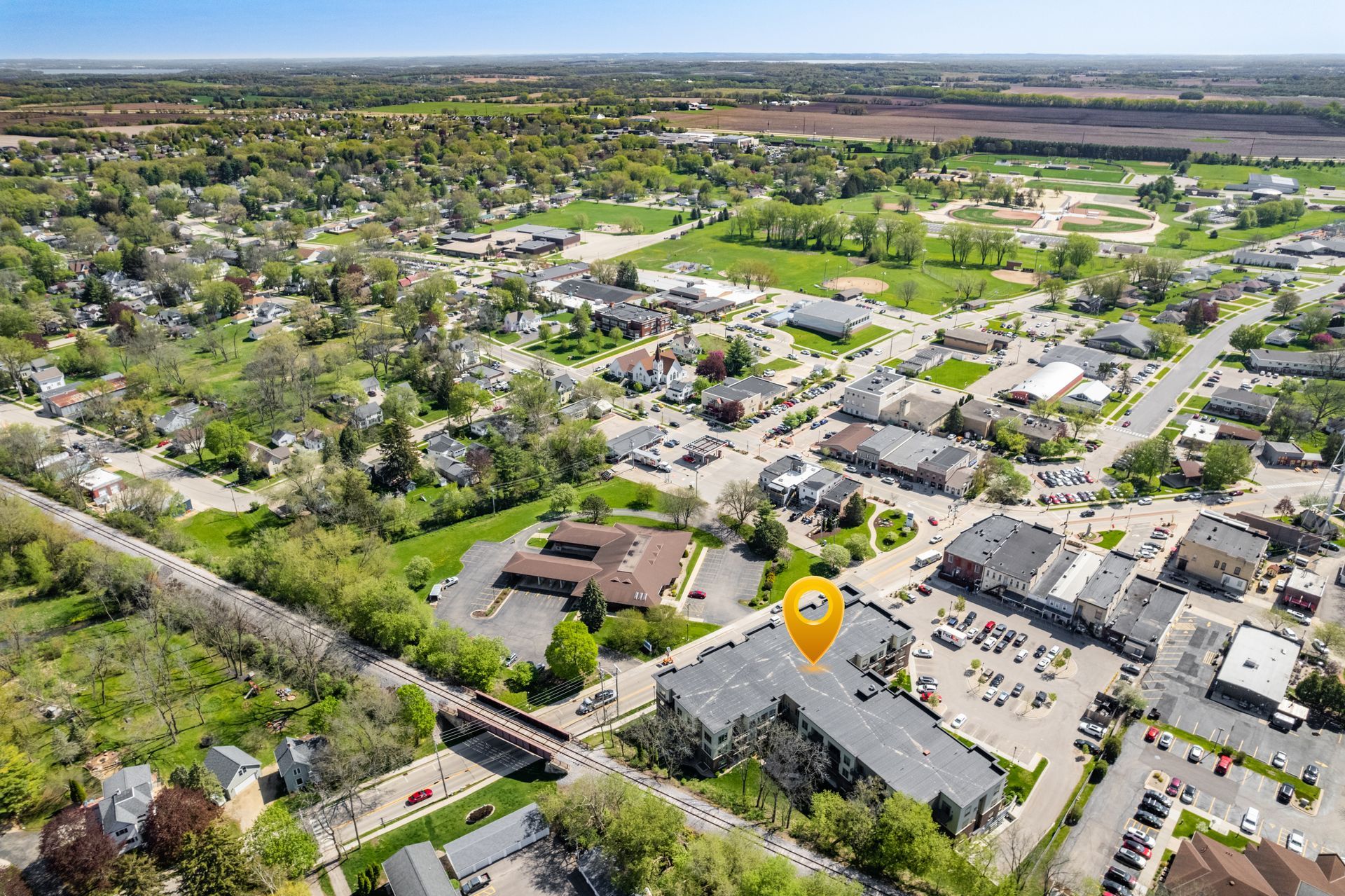an aerial view of a small town with a yellow marker pointing to a building