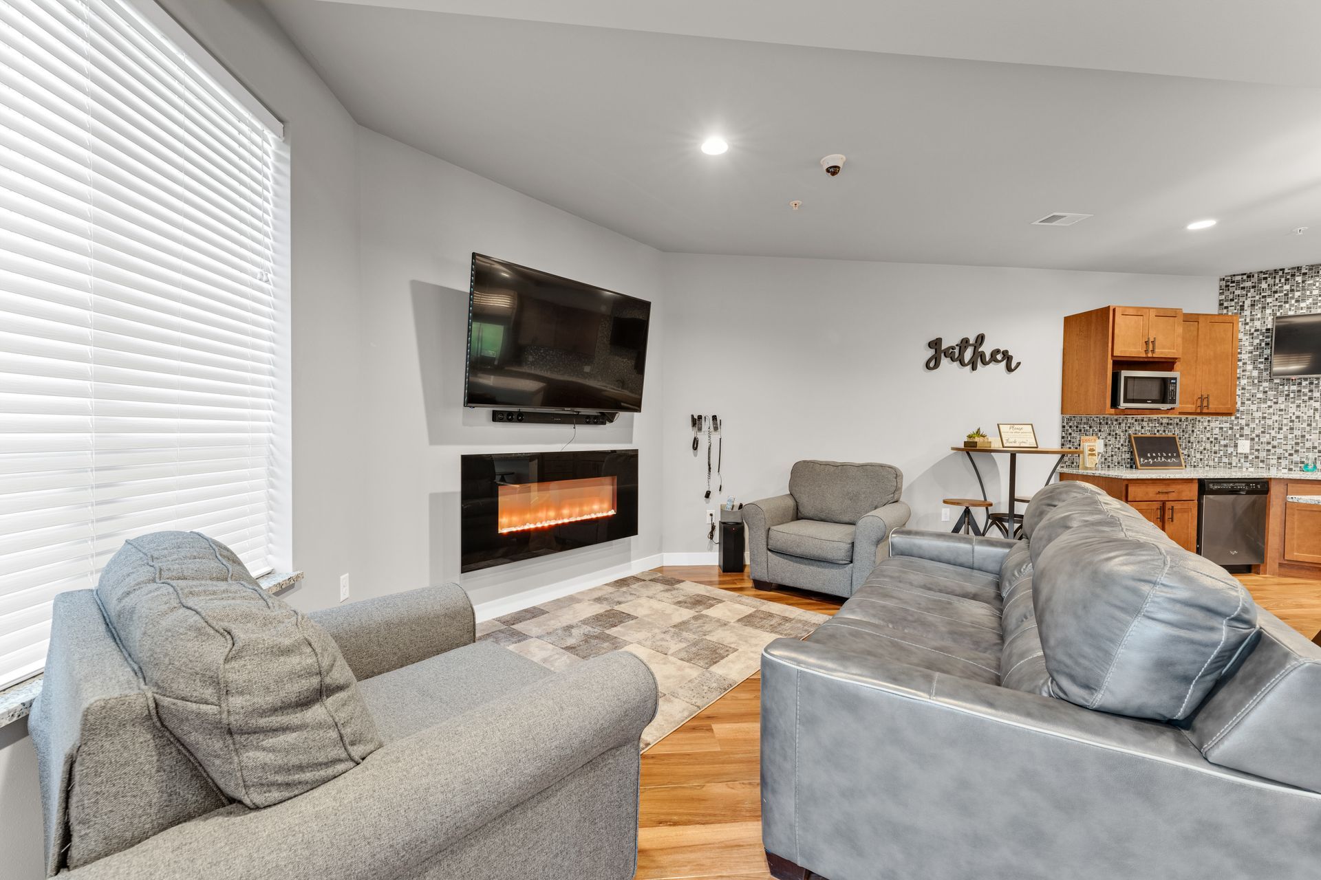 a living room with a fireplace and a sign that says gather