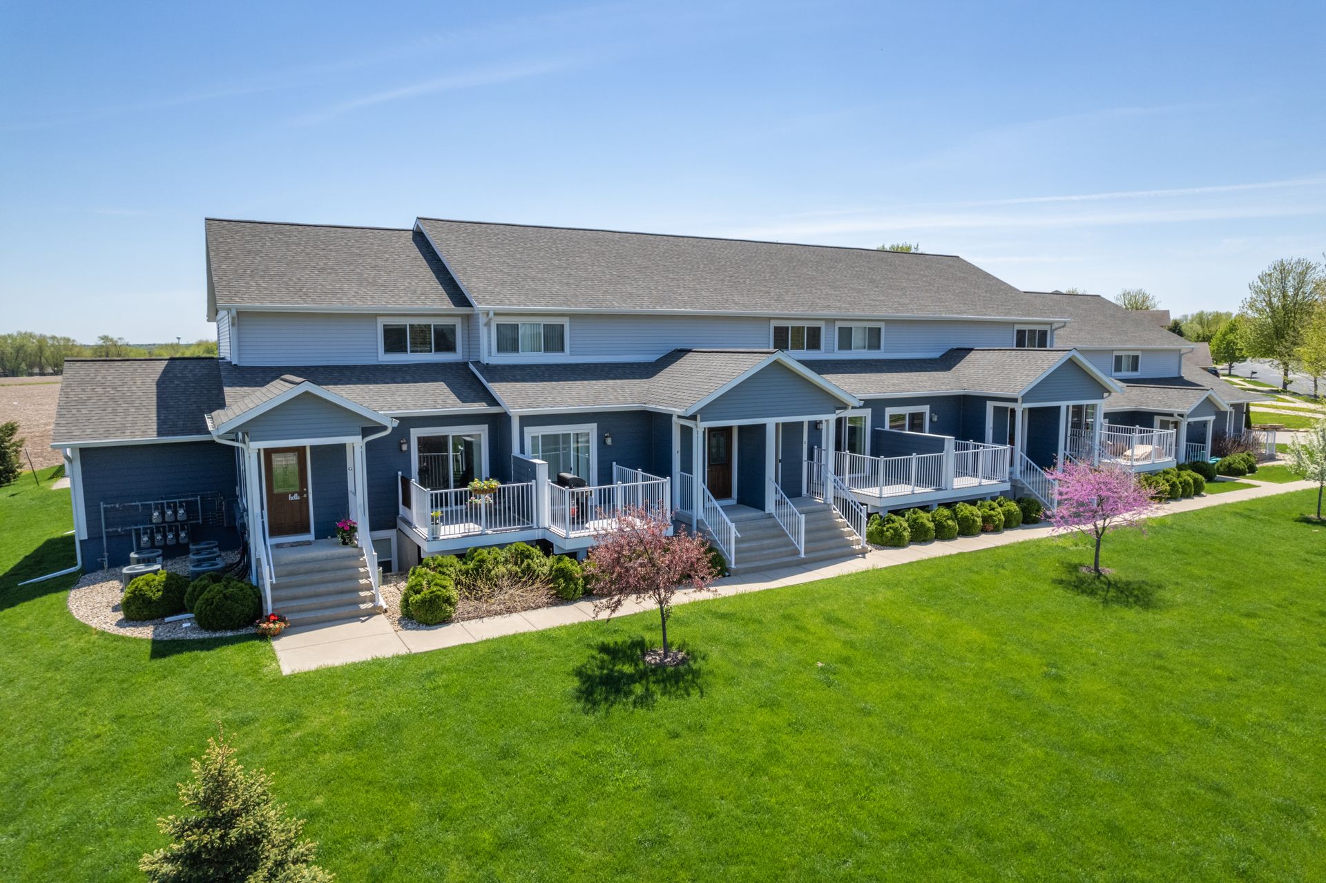 a row of houses with a lush green lawn in front of them