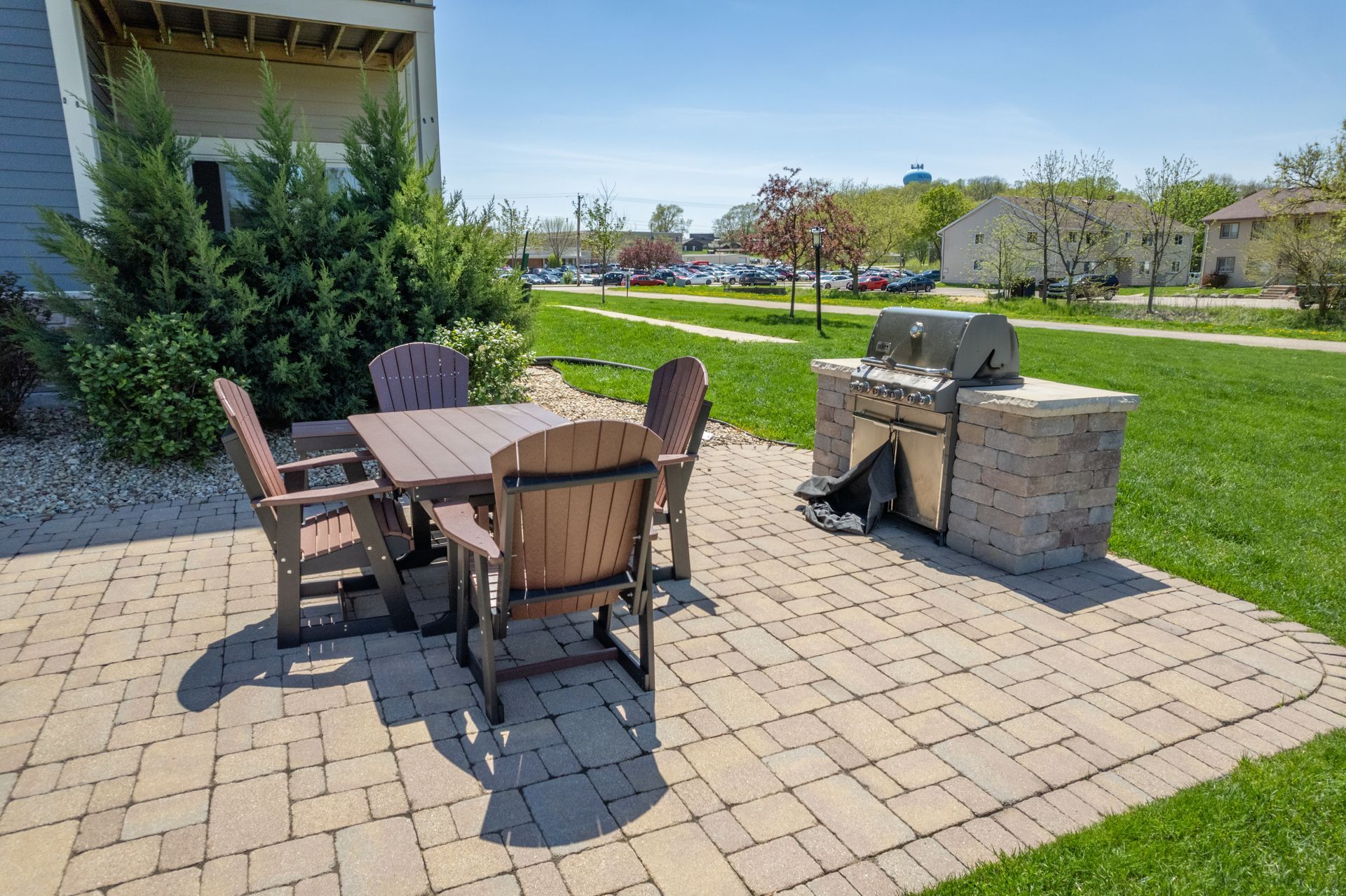 a patio with a table and chairs and a grill