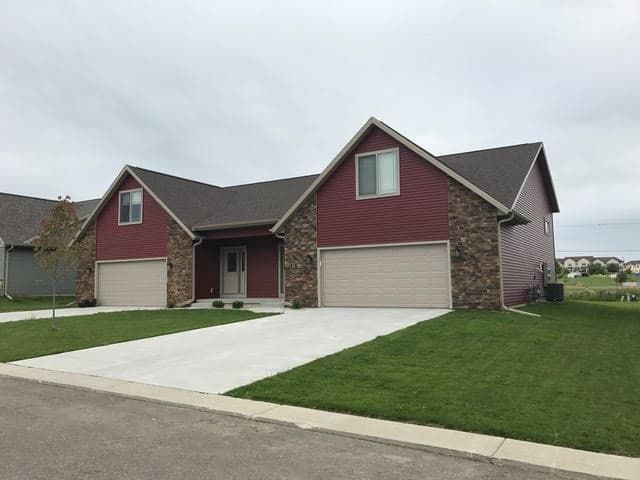 a couple of red houses with two garages in a residential area .