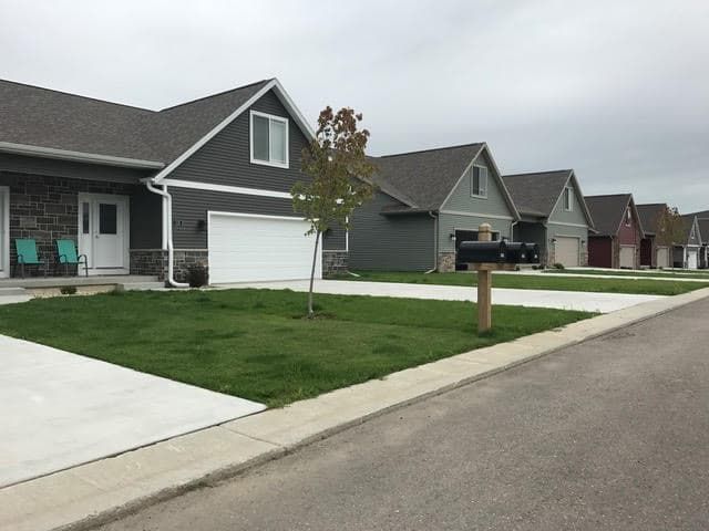a row of houses in a residential neighborhood with a mailbox in the middle of the street .