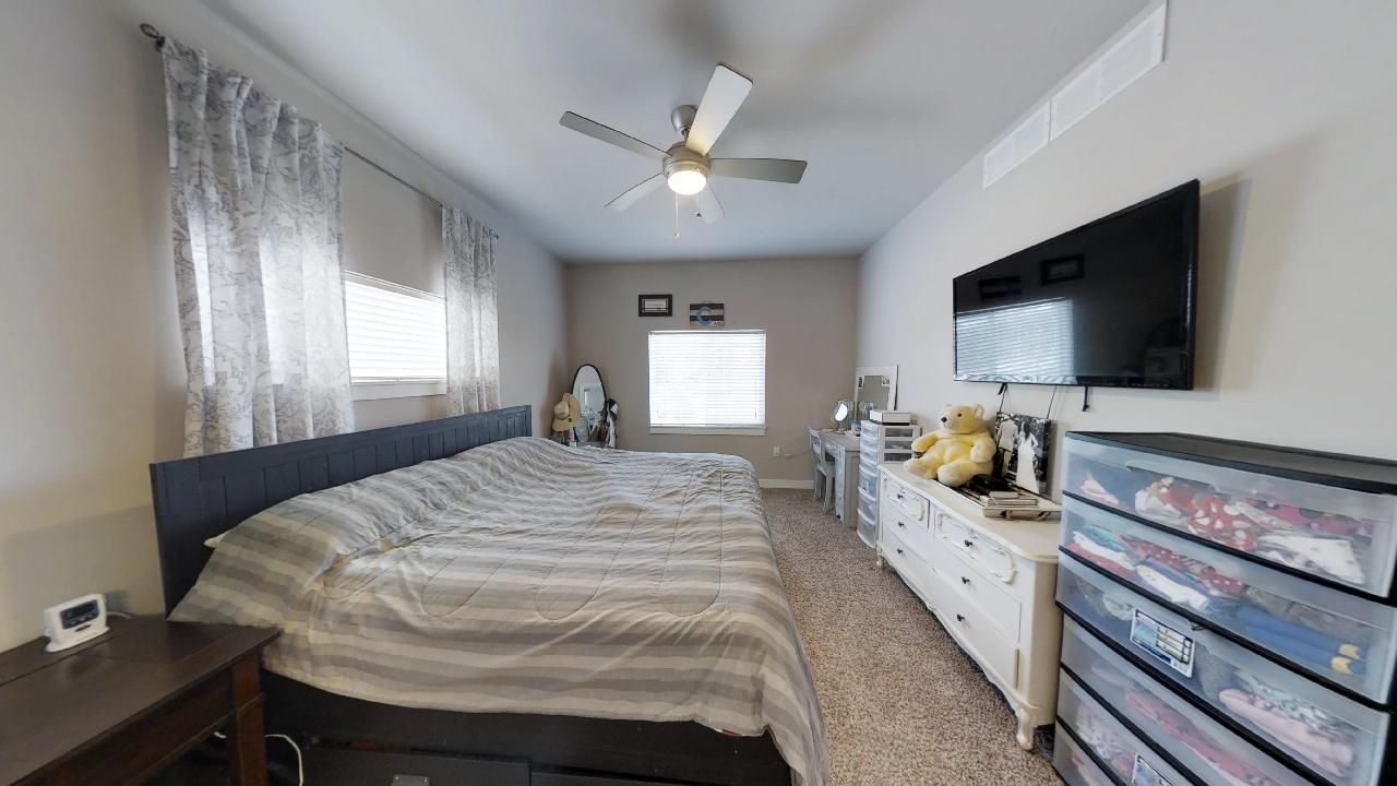 a bedroom with a large bed and a flat screen tv