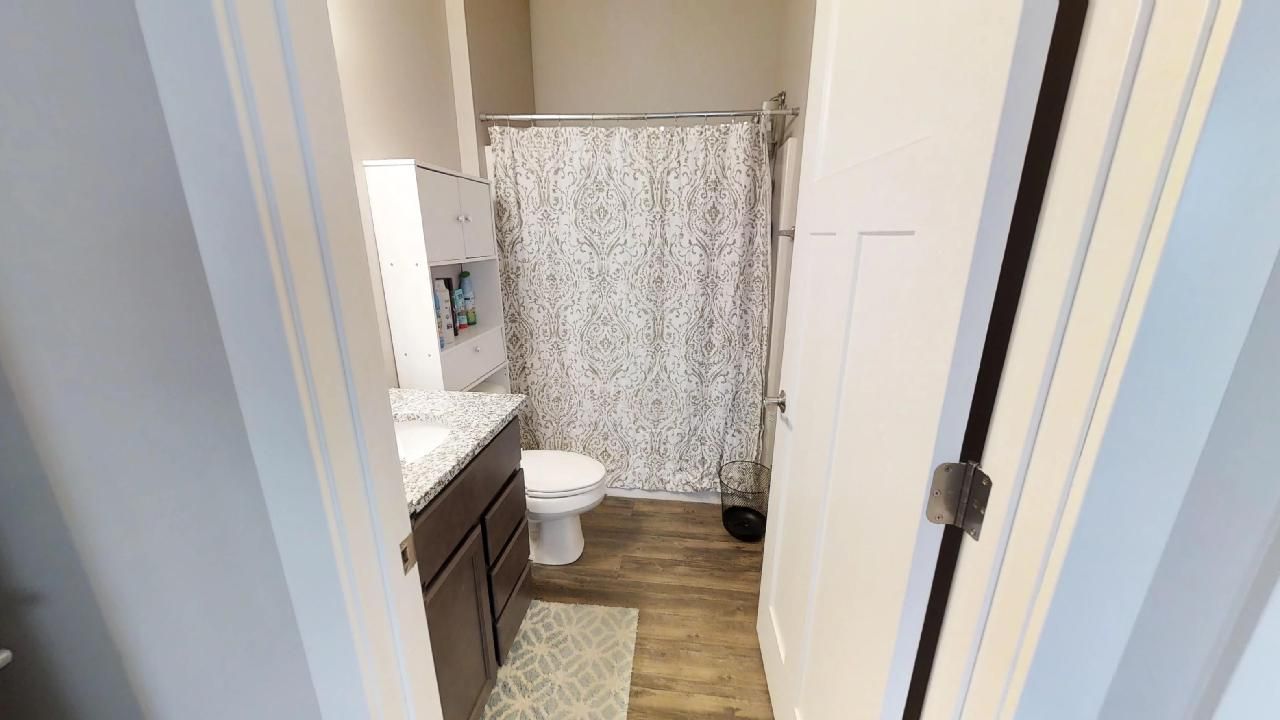 a bathroom with a toilet and a shower curtain