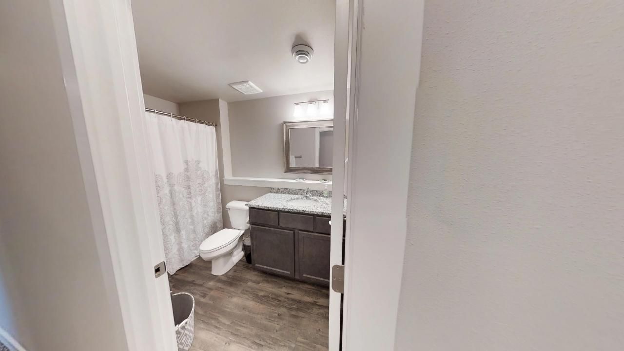 a bathroom with a toilet a sink and a shower curtain