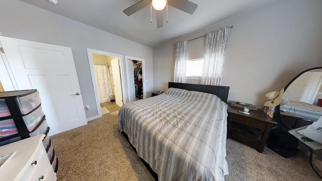 a bedroom with a bed and a ceiling fan