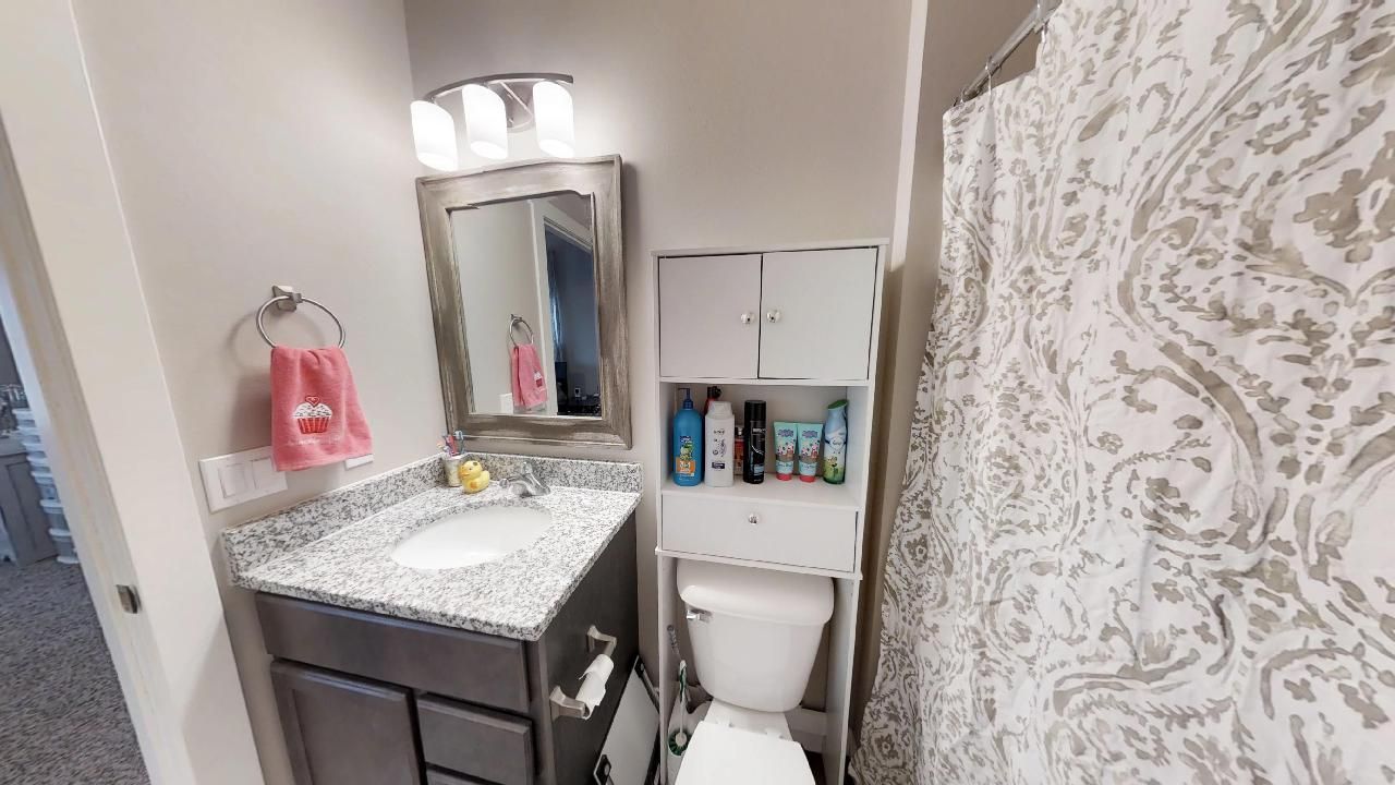 a bathroom with a toilet a sink and a mirror