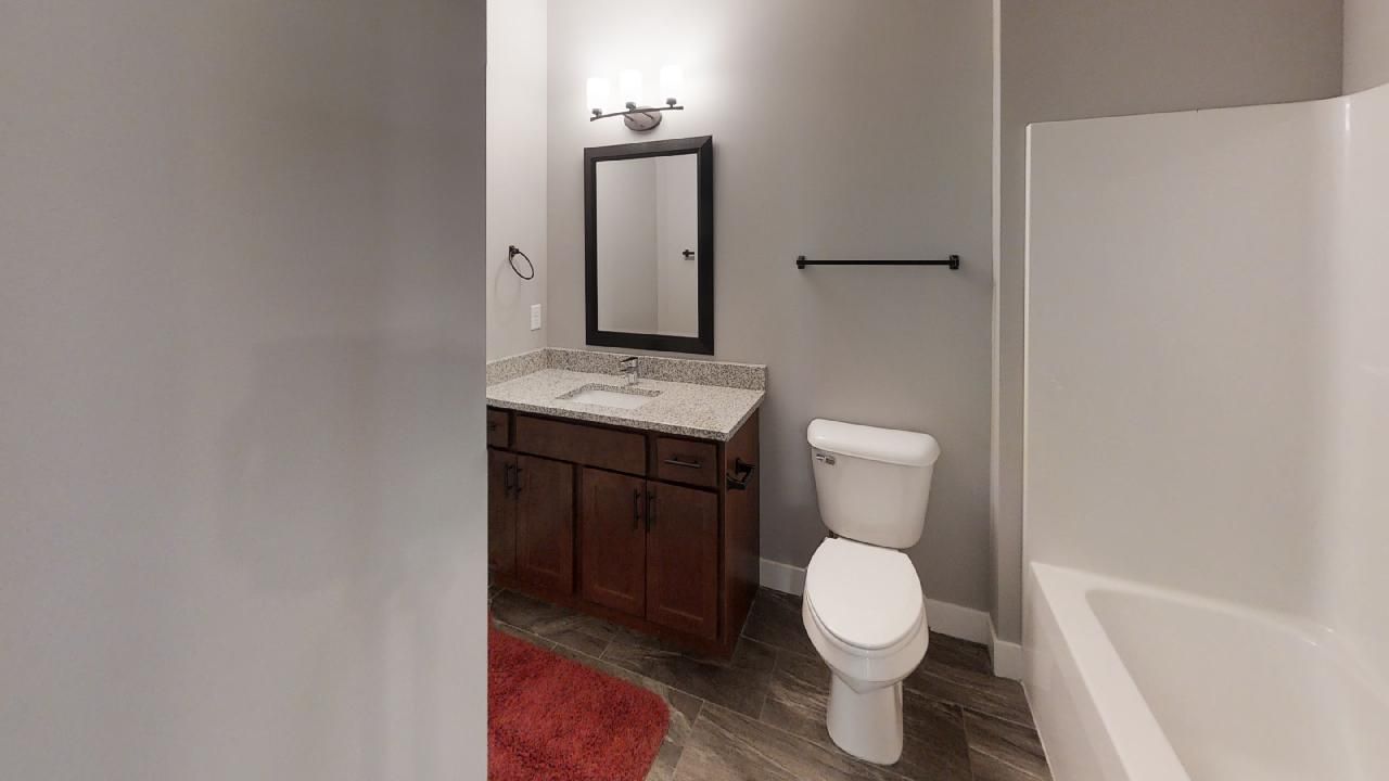 a bathroom with a toilet a sink and a mirror