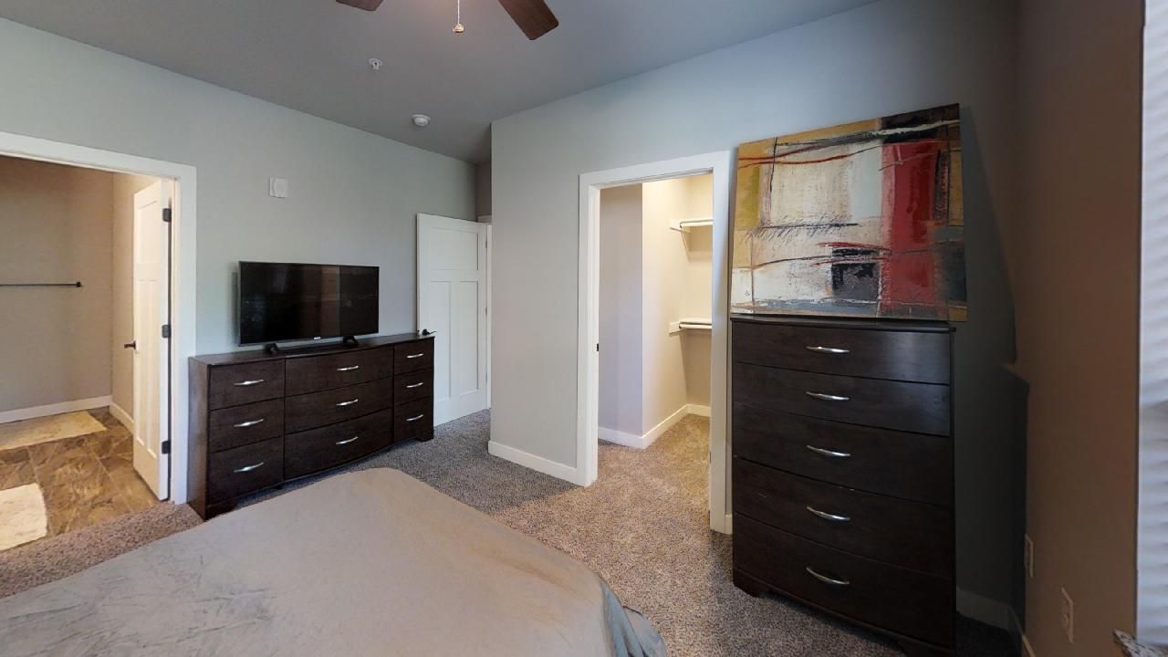 a bedroom with a dresser and a flat screen tv