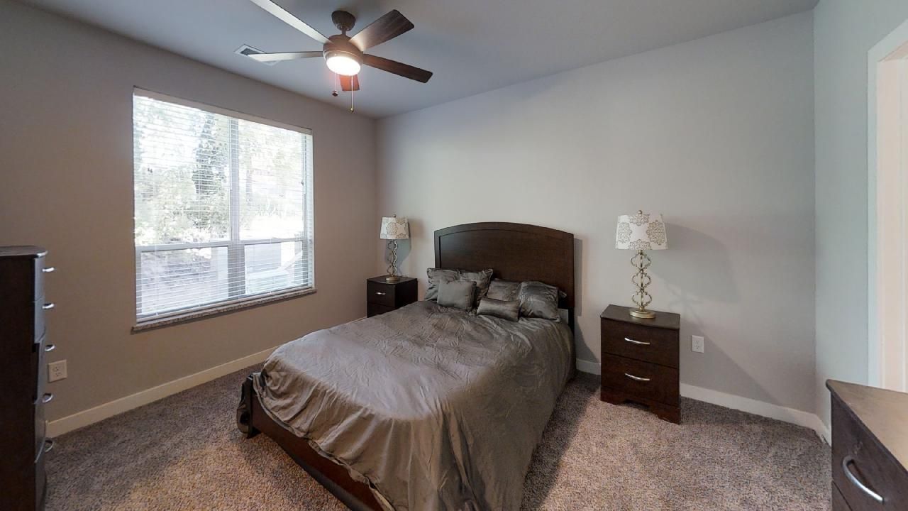 a bedroom with a bed and a ceiling fan