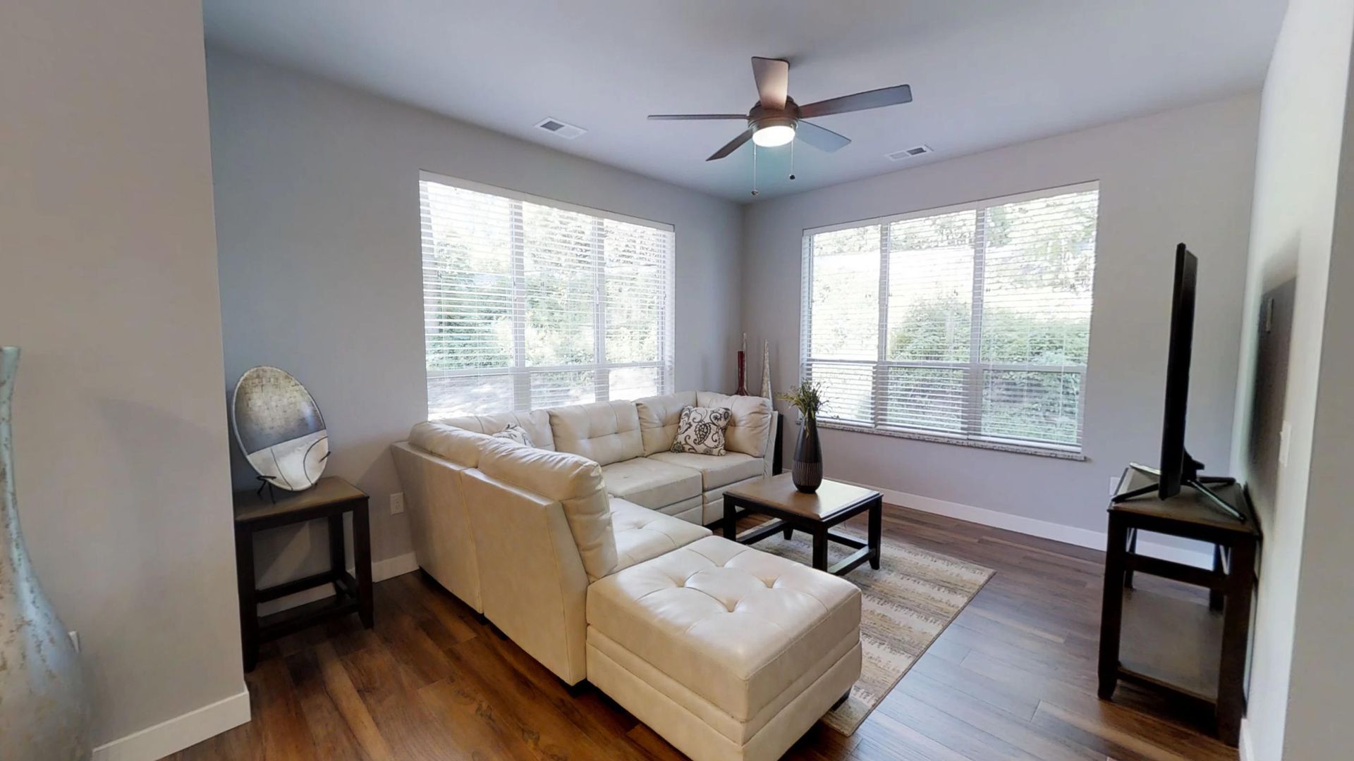 a living room with a sectional couch and a flat screen tv