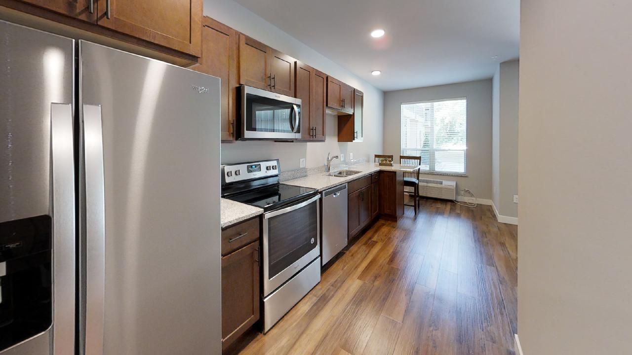 a kitchen with stainless steel appliances including a whirlpool refrigerator