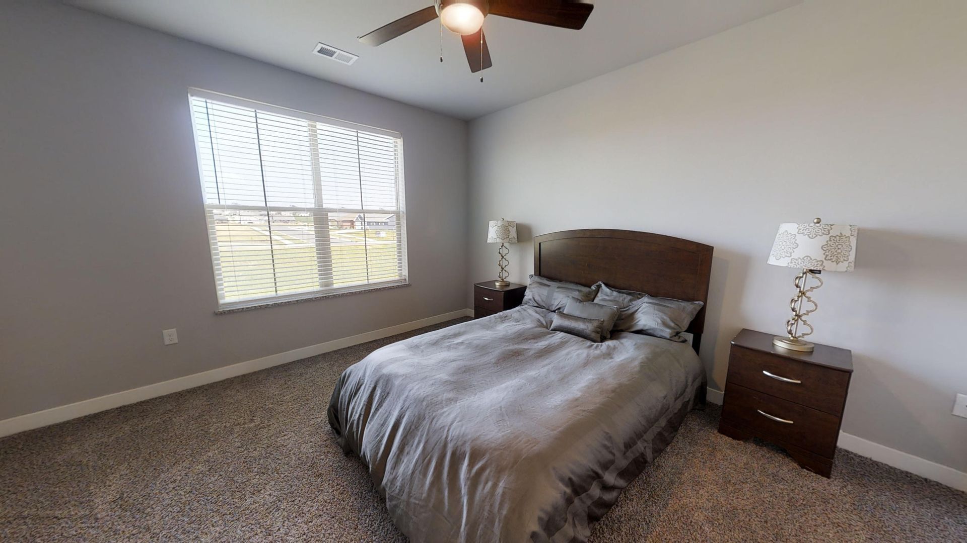 a bedroom with a bed and a ceiling fan